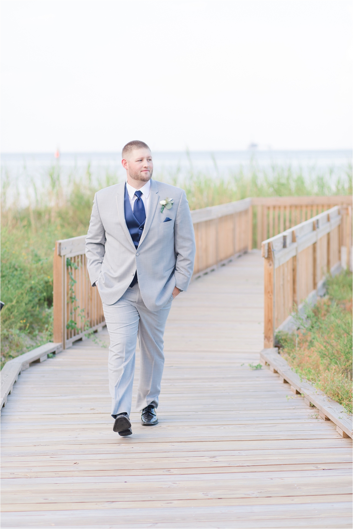 groom-navy-tie-vest-portraits-alabama-wedding-photographer-Dauphin Island Estuarium-on the beach-beach-dock