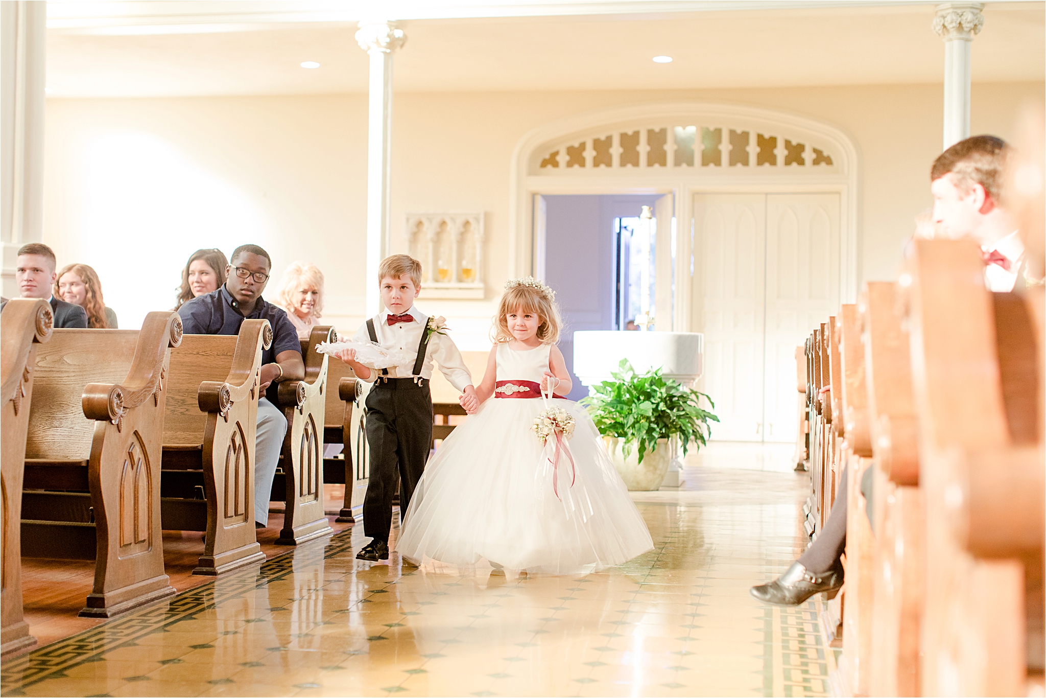 flower-girl-ring-bearer-holding-hands-walking-down-aisle-cranberry-wedding-colors-full-skirt