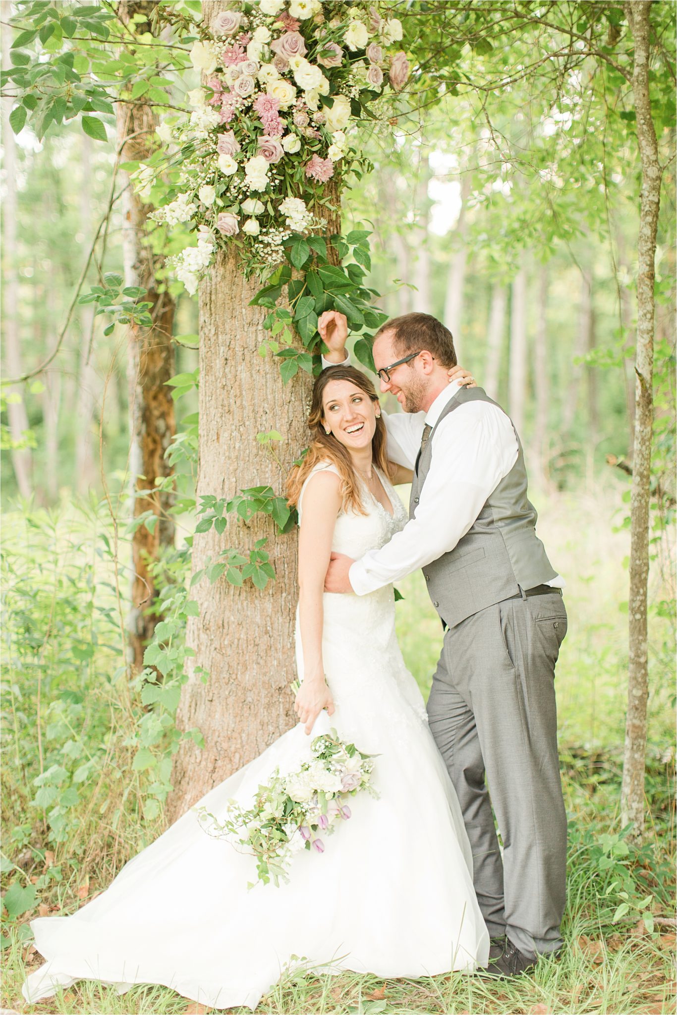 backyard country wedding-decorate trees with wedding flowers-bride and groom portraits-wedding day-grey grooms suit-vest-lavender flowers-candid laughter