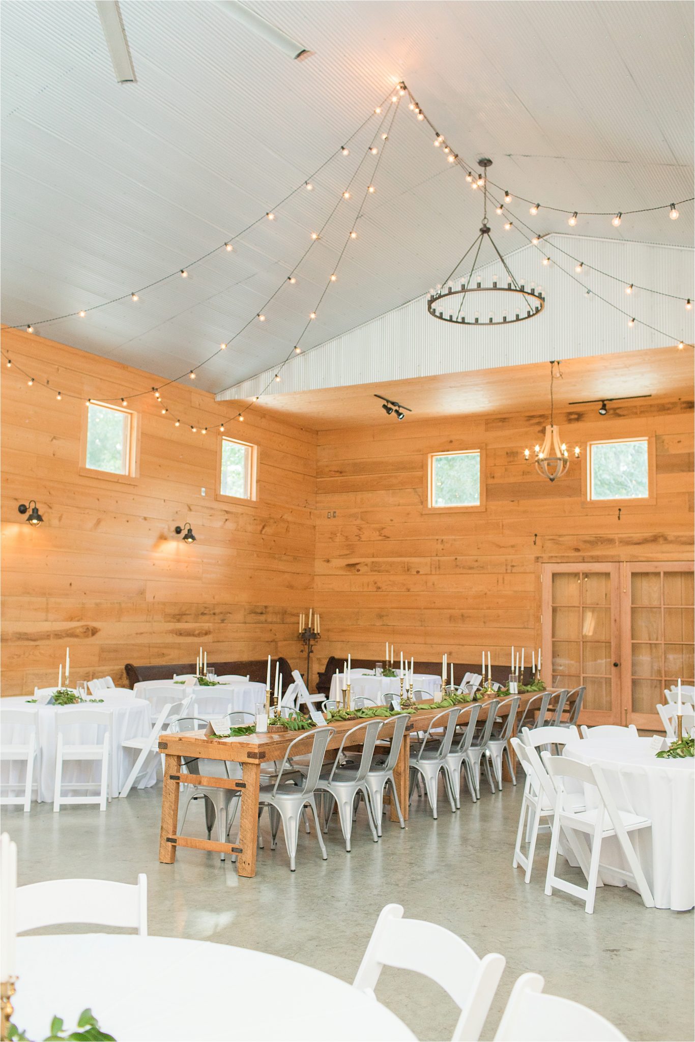 wedding-reception-alabama-venue-barn-farm-tables-metal-chairs-candle-centerpieces-hanging-lights